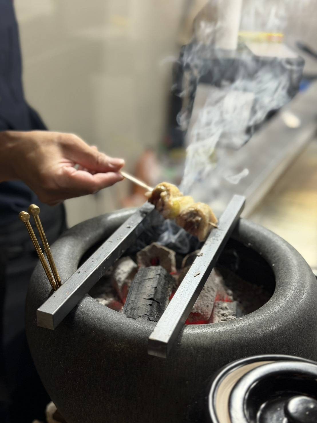 火鉢の炭火で串を焼く店主の手元